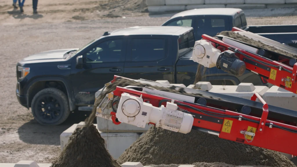 Sand conveyors beside trucks