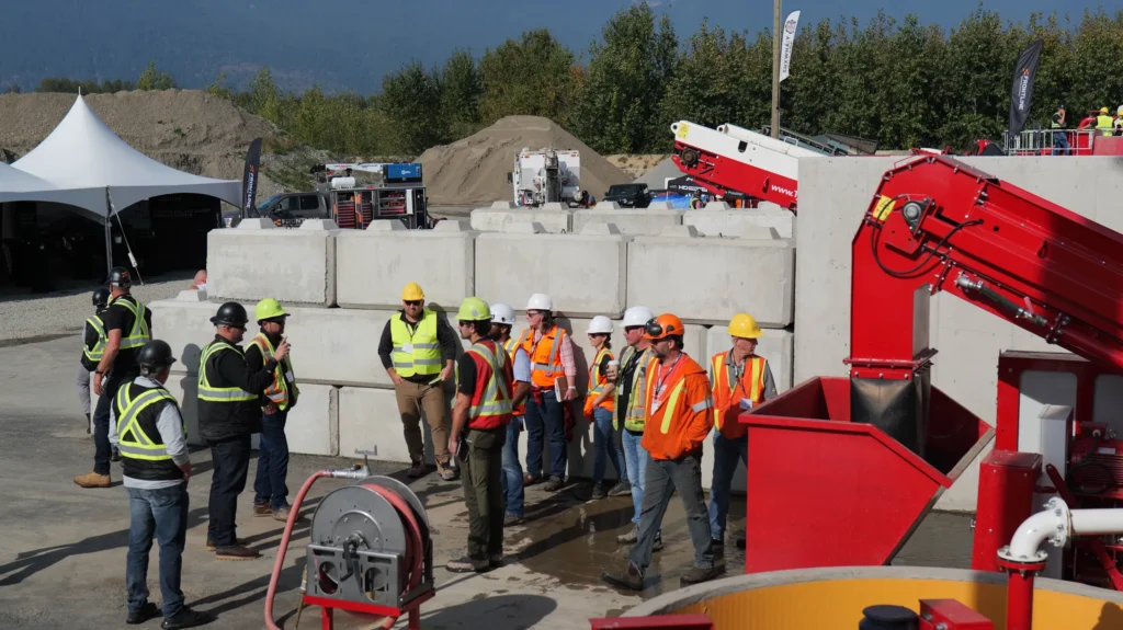 A group of attendees stands against a concrete block wall at the RECLAIM 2026 event