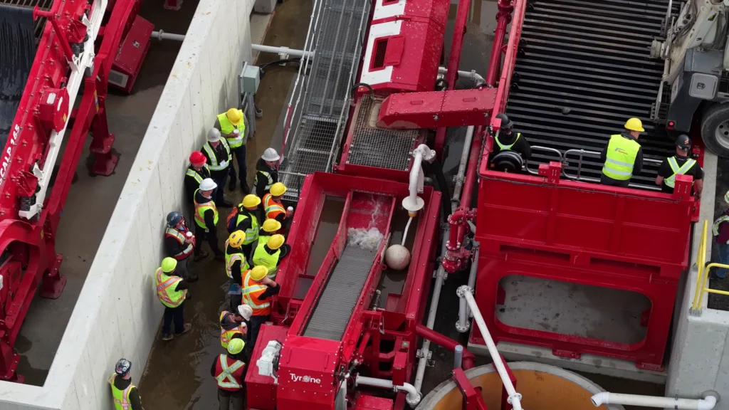 Aerial view of attendees standing along a concrete wall beside Tyrone wash equipment